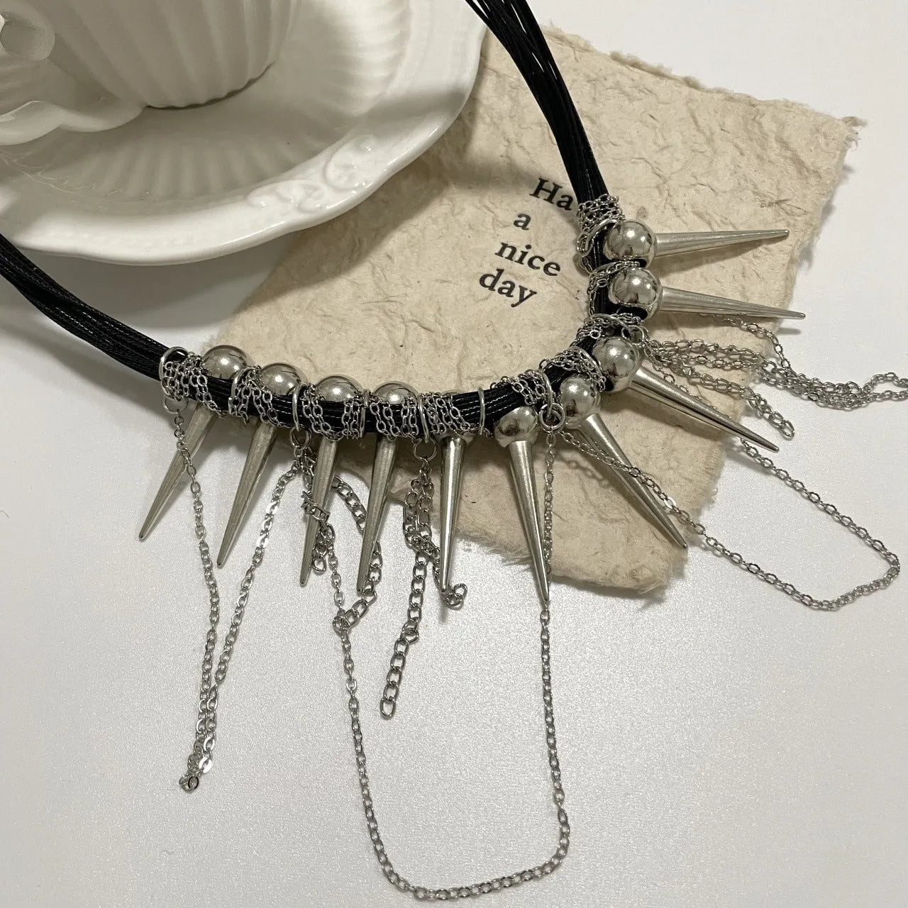 Leather necklace with round beads and winding tassel featuring rivet details in picture colour