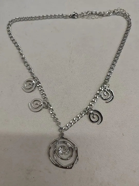 Gold spiral donut necklace, bracelet, and ear hooks set for women on a plain background.