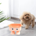 Green elevated cat bowl with robot shape design on anti-slip base showing tilted angle for feeding