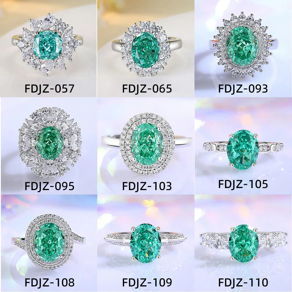 Women's oval emerald and diamond ring in sterling silver on a hand.