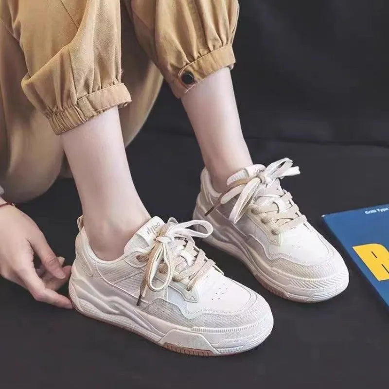 Women's low-top pink and white sneakers with a rubber sole and imitation leather lining.