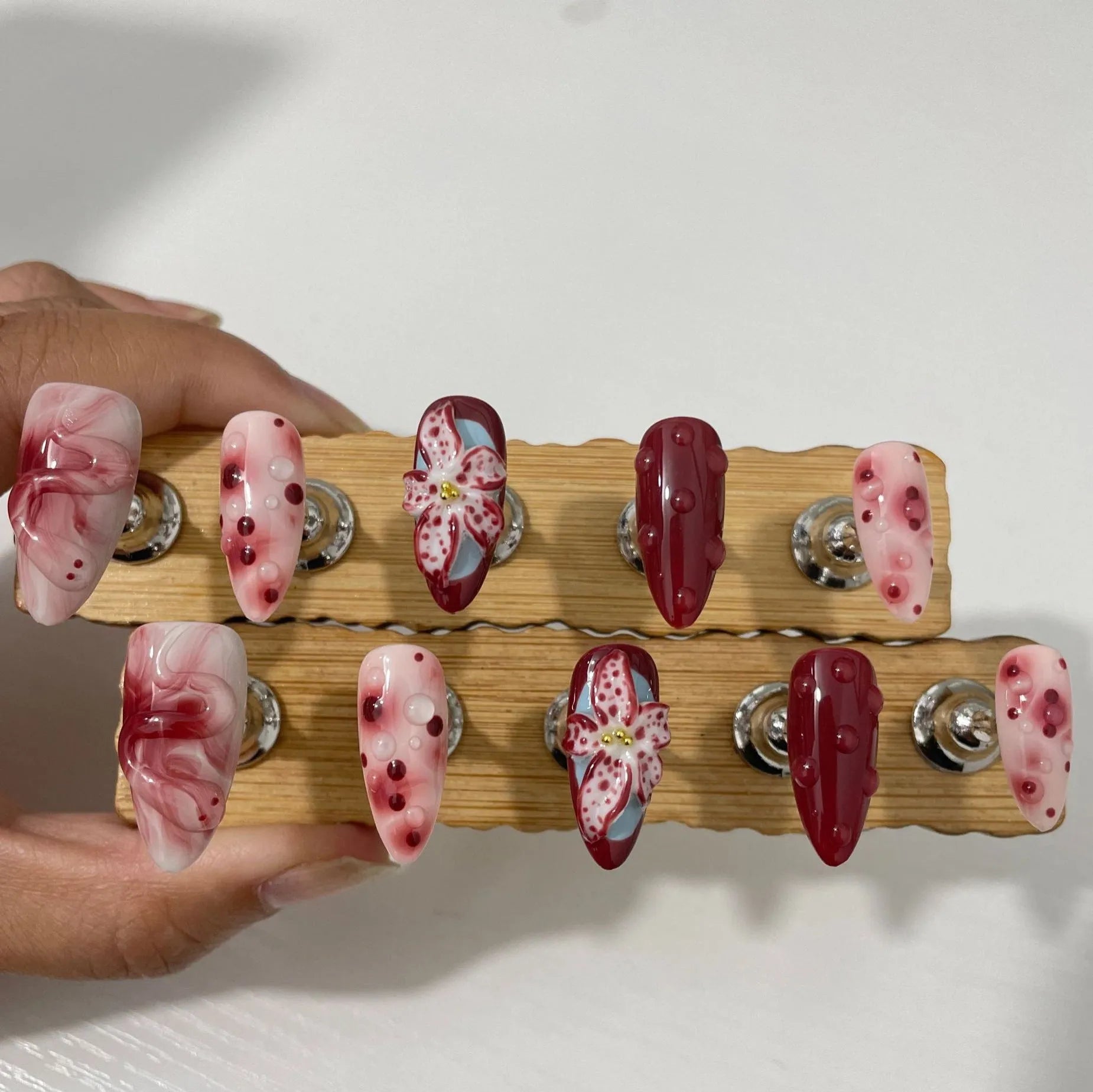 False nails with 3D carved floral and decorative patterns in almond shape, showing size options