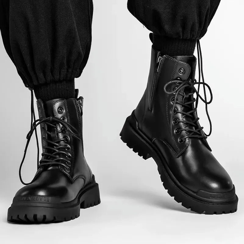 Men's black mid-top leather lace-up boots with a rubber sole on a wooden floor