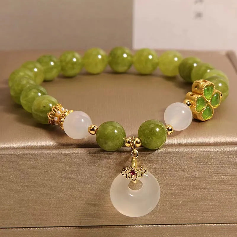 Natural stone green tourmaline women's bracelet with peace buckle and lucky bag charm on display