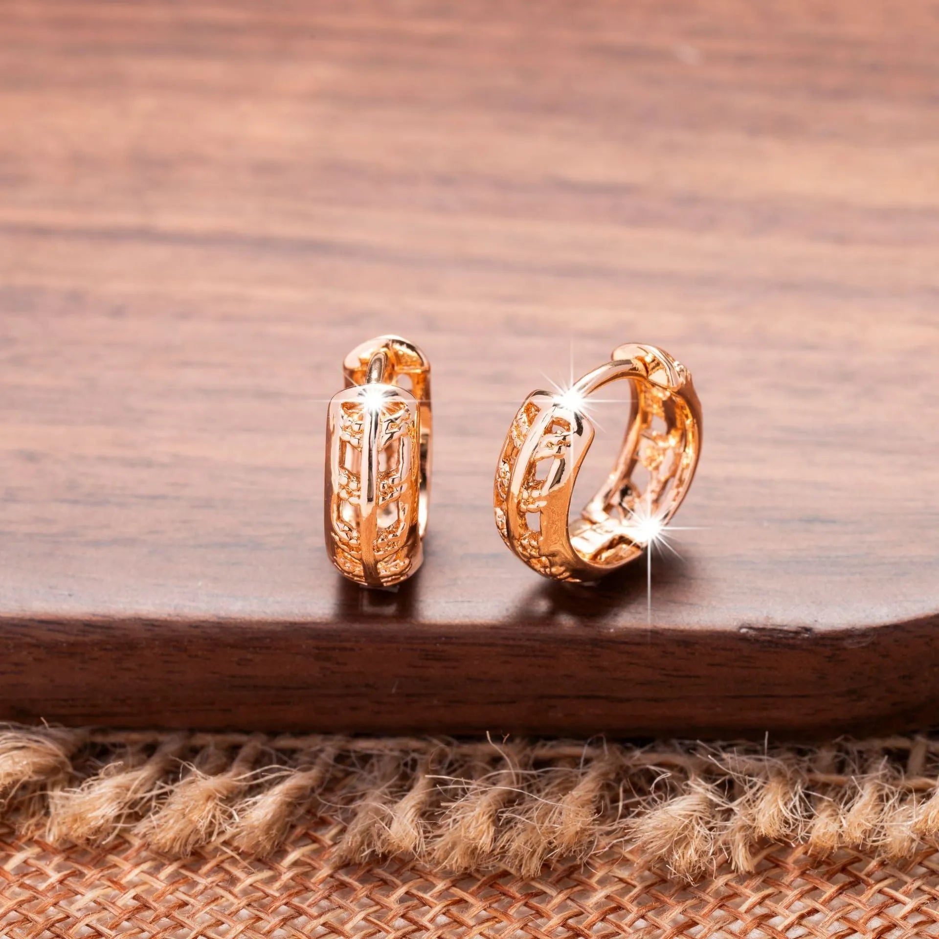 Rose gold hollowed out earrings with heart and leaf shapes on copper background