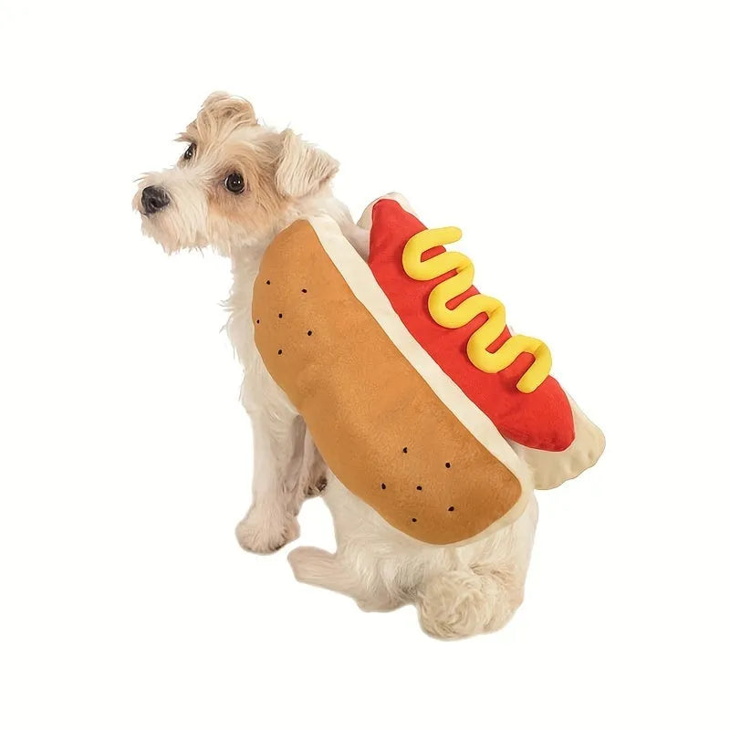 A small dog wearing a plush red and brown hot dog costume with elastic straps.