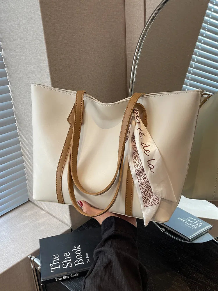 Women's large capacity soft tote bag with crossbody strap showing zipper compartment interior