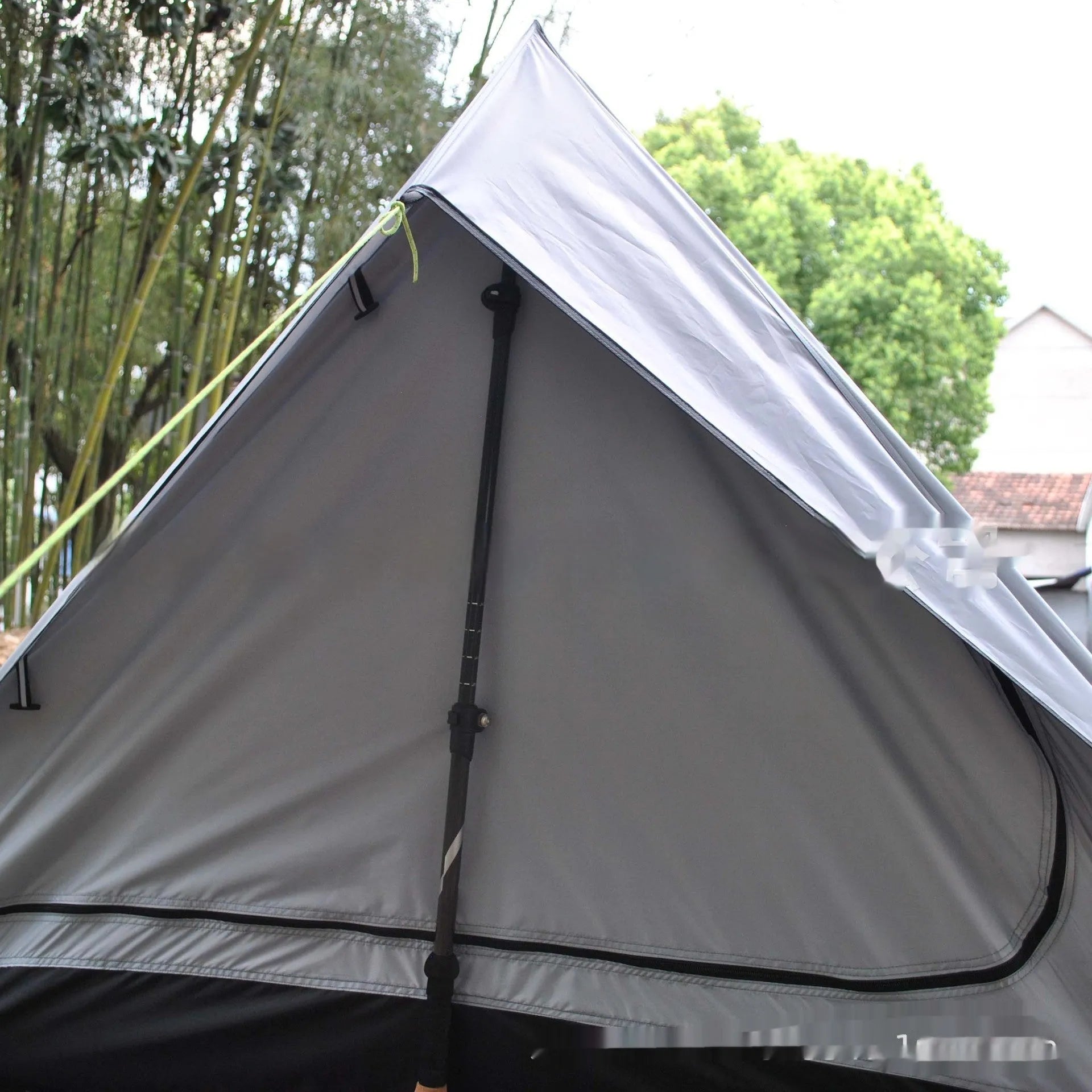 Brown A-frame hiking tent supported by hiking poles showing spacious interior for 2-3 campers