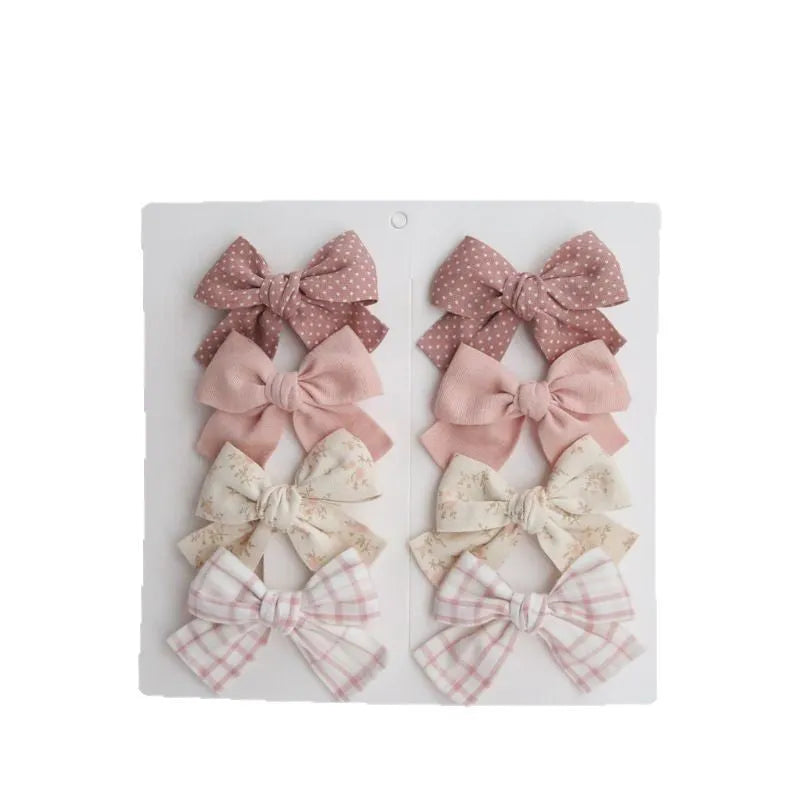 Children's fabric dovetail bow hairclips in eight colour sets including beige, blue flowers, coffee polka dot, green dots, pink, rice coffee, wine red plaid floral, and yellow