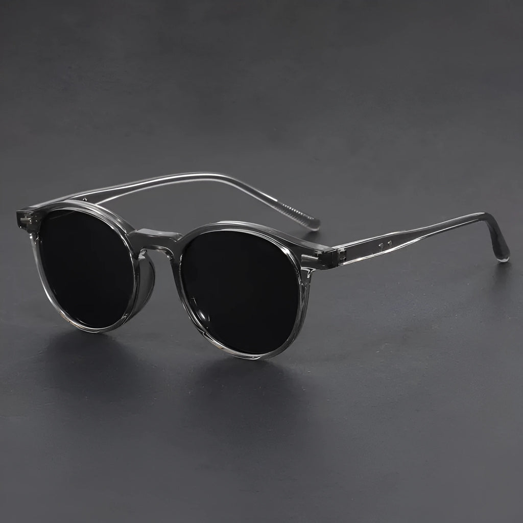 Ultra-light round frame retro sunglasses with polarised gray lenses in multiple colours including sand black, bright black, and gray
