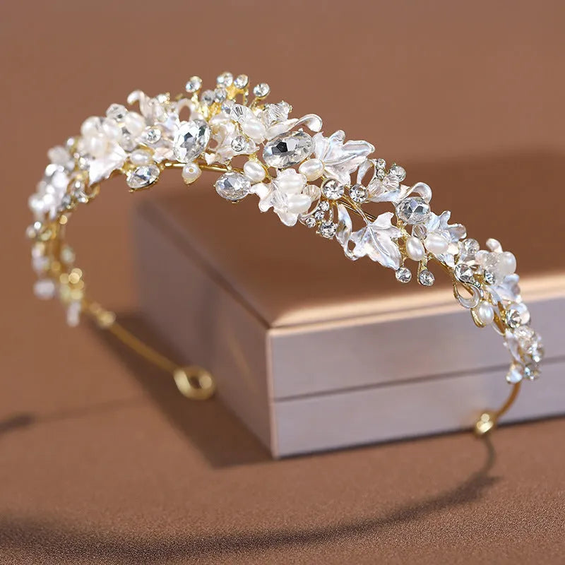 Gold metal alloy crown headdress with a white pearl-like decoration for women.
