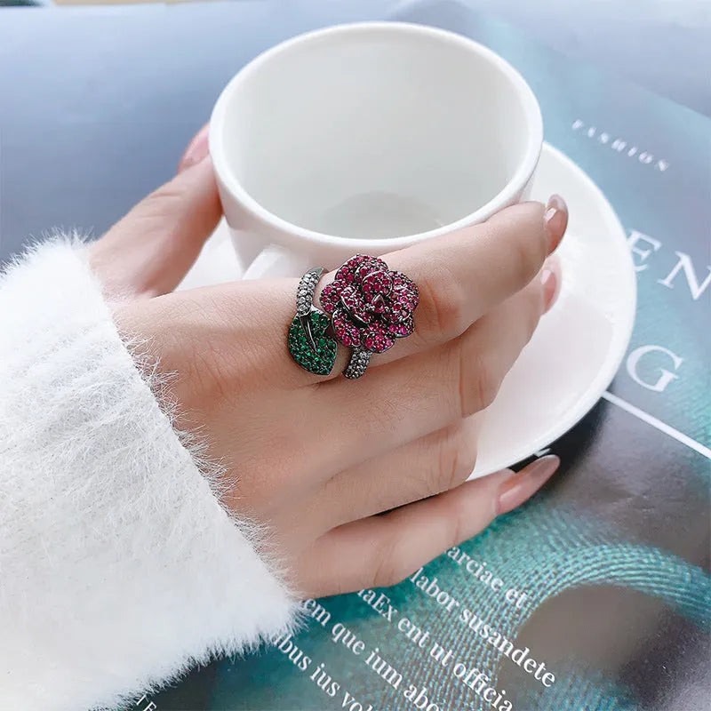 Women's black gold-plated geometric ring with red simulated corundum stones on a copper base.