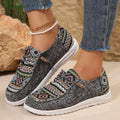 Women's black flat shoes with round toe and slip-on design on neutral background