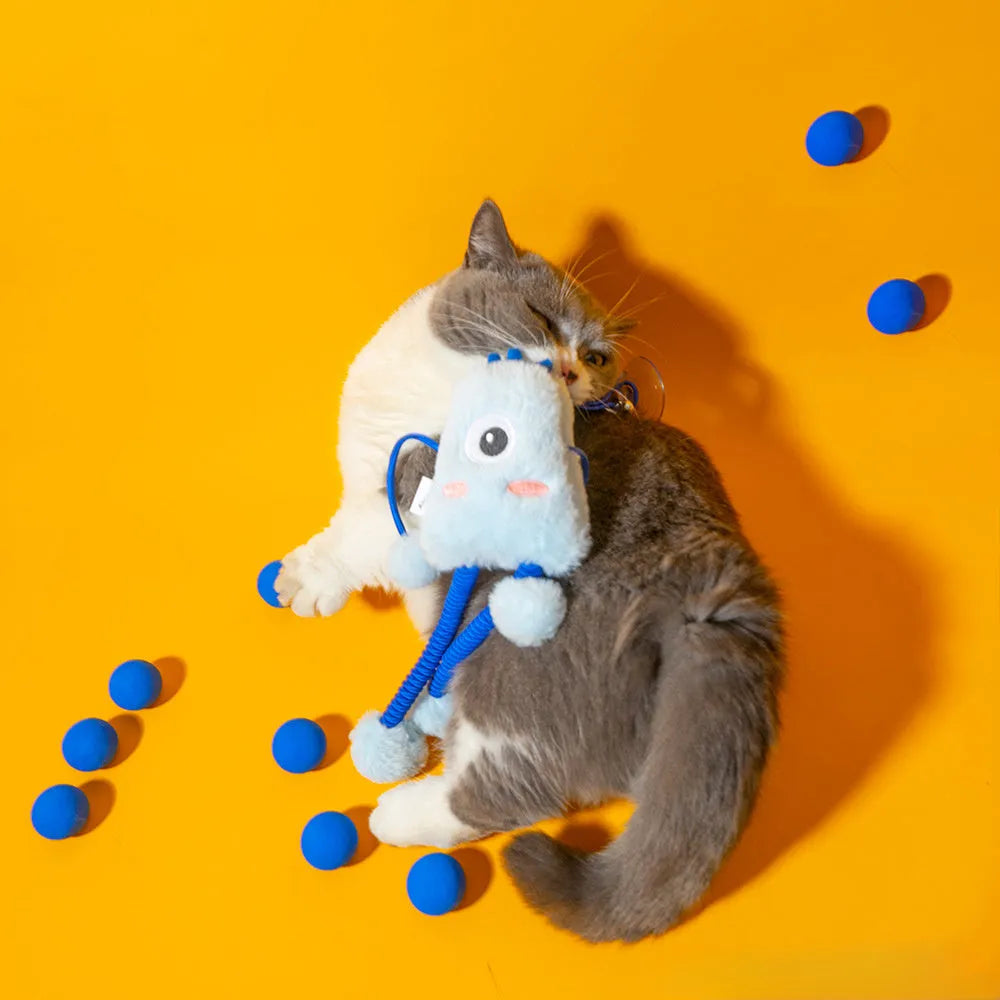 Blue plush cat toy with mint bell and elastic rope on floor