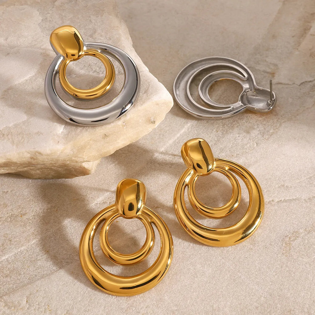 Round golden geometric hollow stud earrings made from titanium steel with an 18K gold electroplated finish.