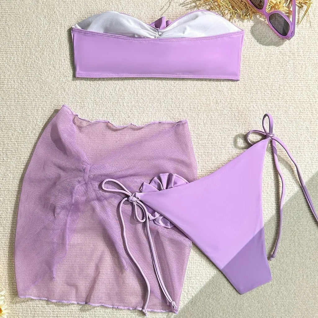 Women's pink tube top swimsuit with a large 3D flower, matching pants, and a skirt.