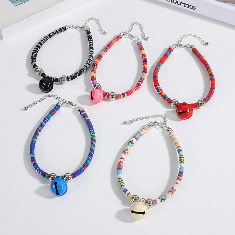 Coloured ethnic pattern adjustable pet collar for dog or cat with a small metal bell attached.