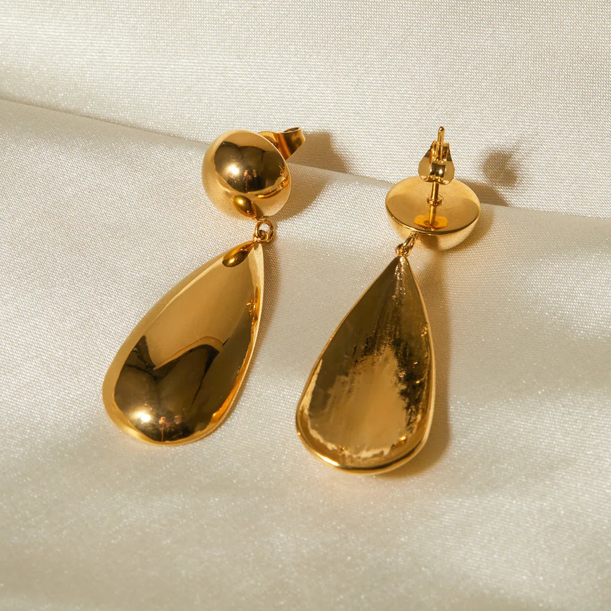 Gold-coloured stainless steel water drop pendant earrings with geometric hemisphere design