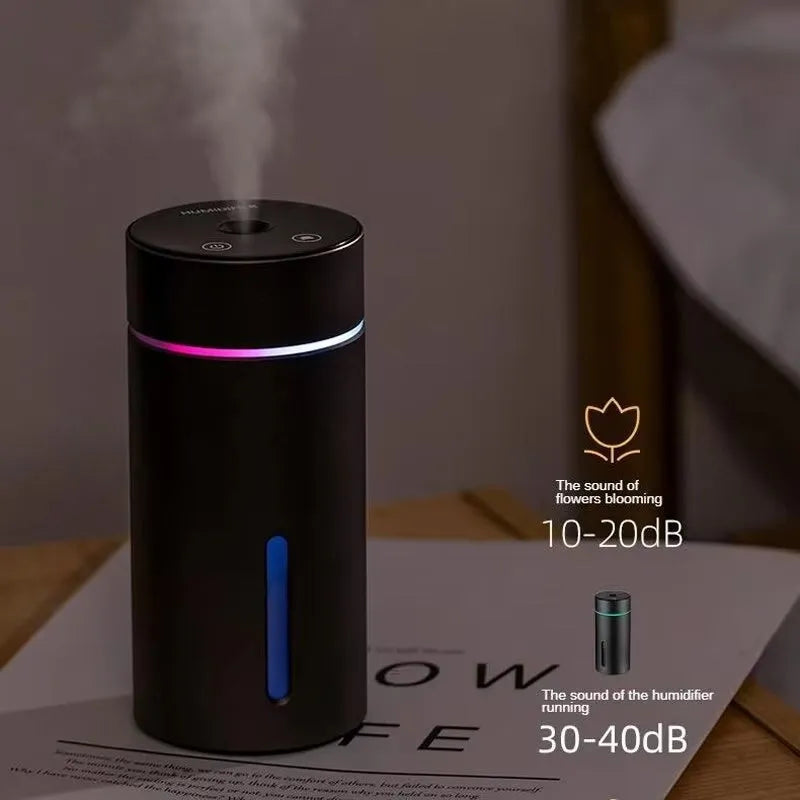 Black A6 aluminium alloy portable car humidifier and essential oil diffuser with USB cable on a desk.
