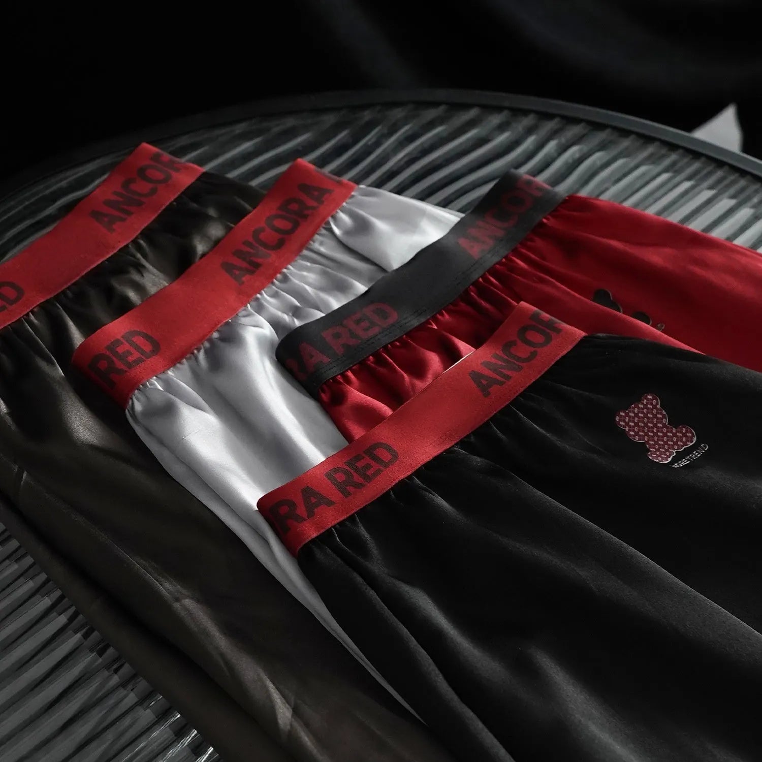 Solid colour men's boxer briefs on a mid waist, available in black, blue, red, silver, purple, and brown.
