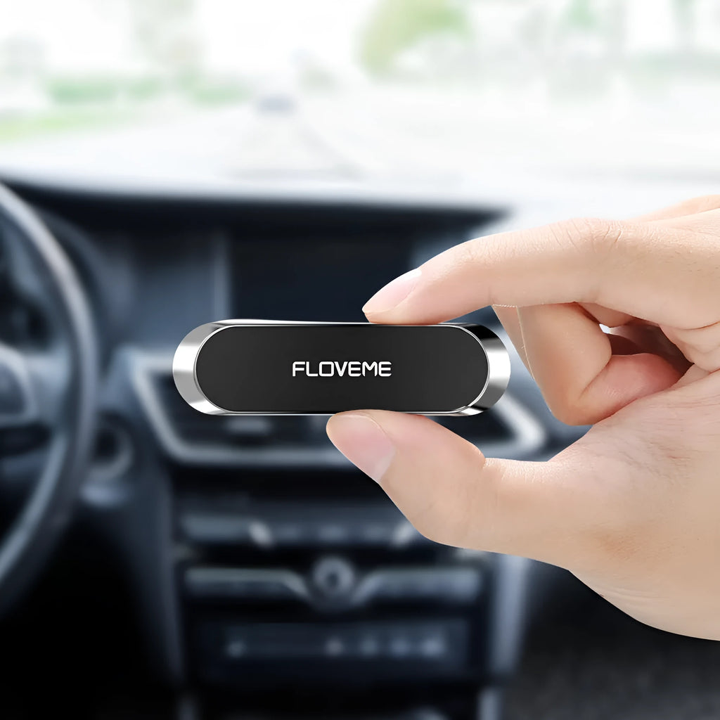 Black magnetic mobile phone holder with silver iron sheet and white foam glue pad on a desk surface