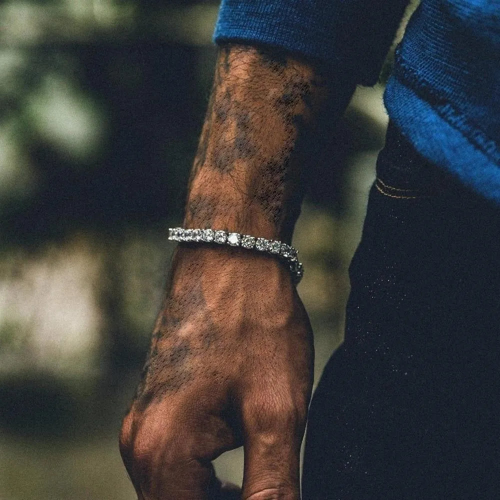 Men's silver geometric link bracelet with rows of clear rhinestones and a dangling tennis racket charm.