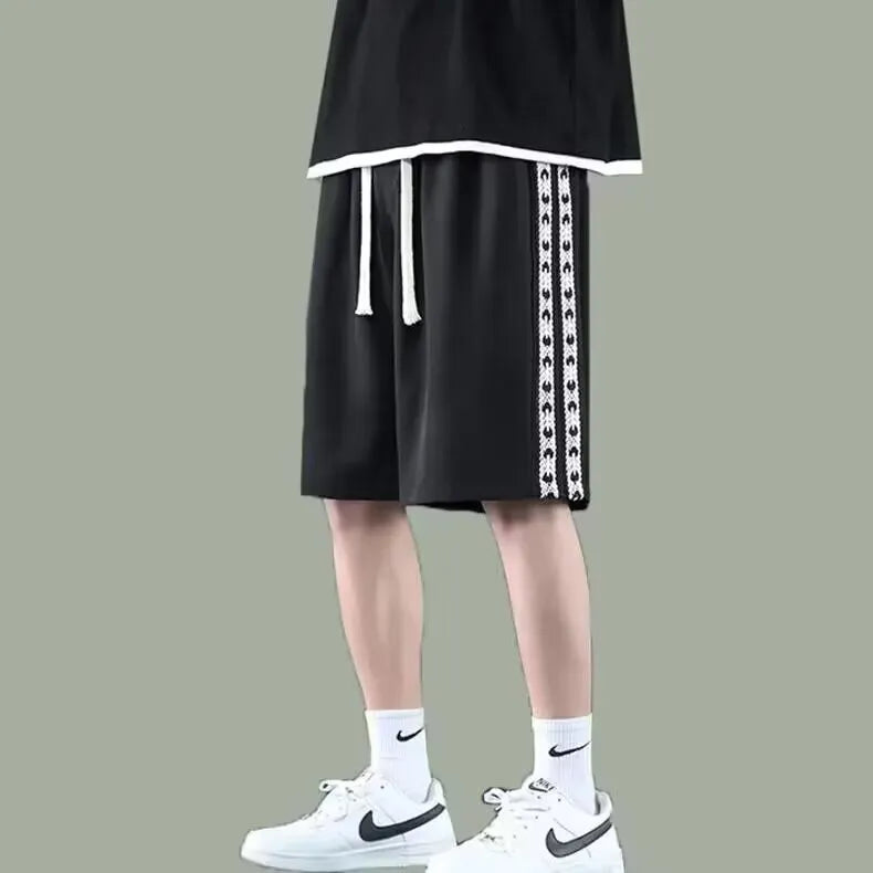 Men's black loose fit track trousers showing baggy sports design with elastic waist
