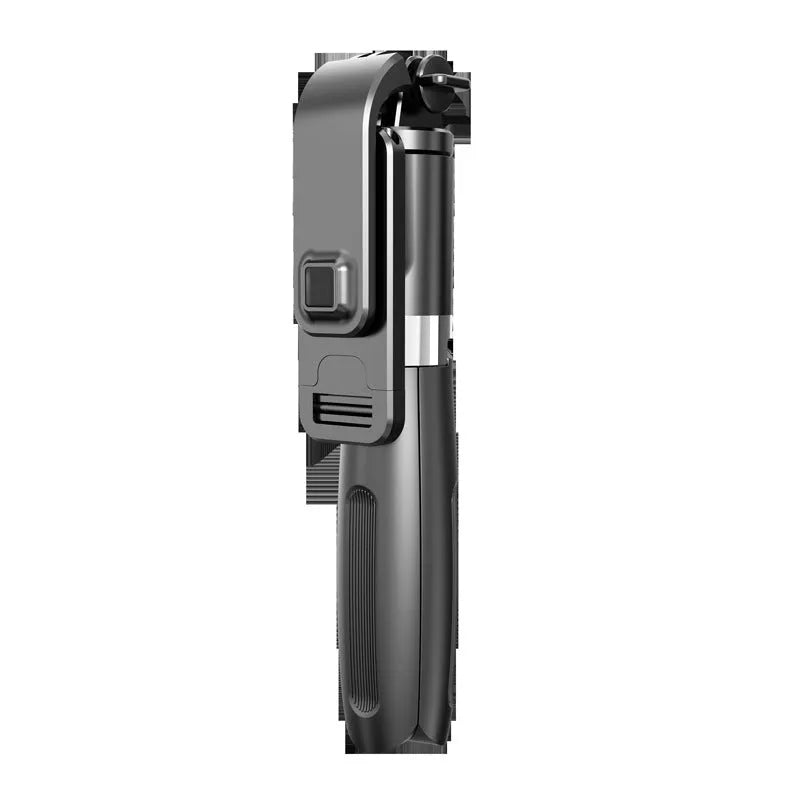 Black Bluetooth selfie stick with wireless remote and tripod extended on table, holding a smartphone in portrait orientation