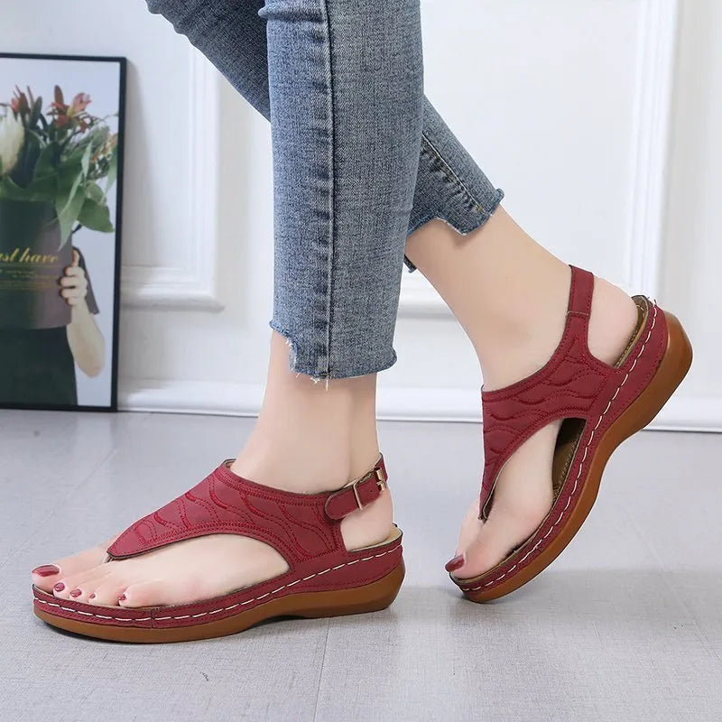Women's black wedge heel sandals with an adjustable buckle strap on a light background.