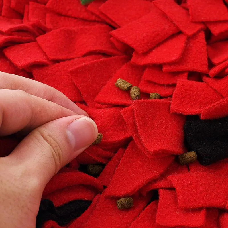 Red and green strawberry-shaped pet sniffing mat for dogs and cats on a wooden floor