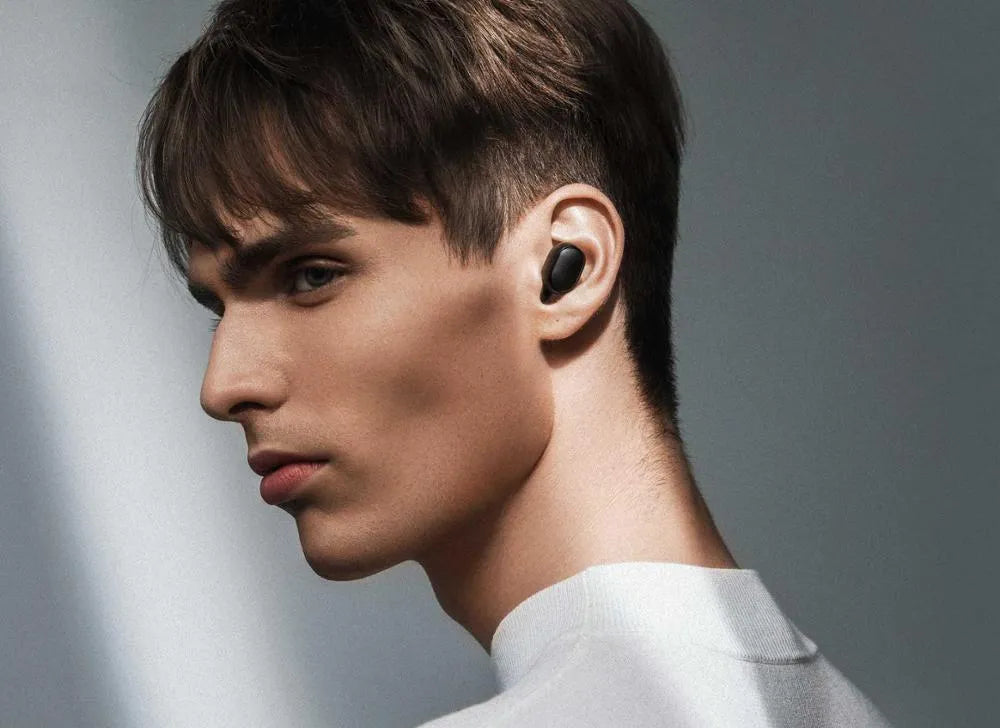 Redmi AirDots black true wireless earbuds and their compact charging case on a white background.