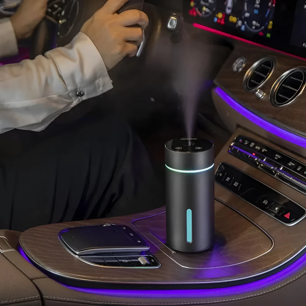 Black A6 aluminium alloy portable car humidifier and essential oil diffuser with USB cable on a desk.