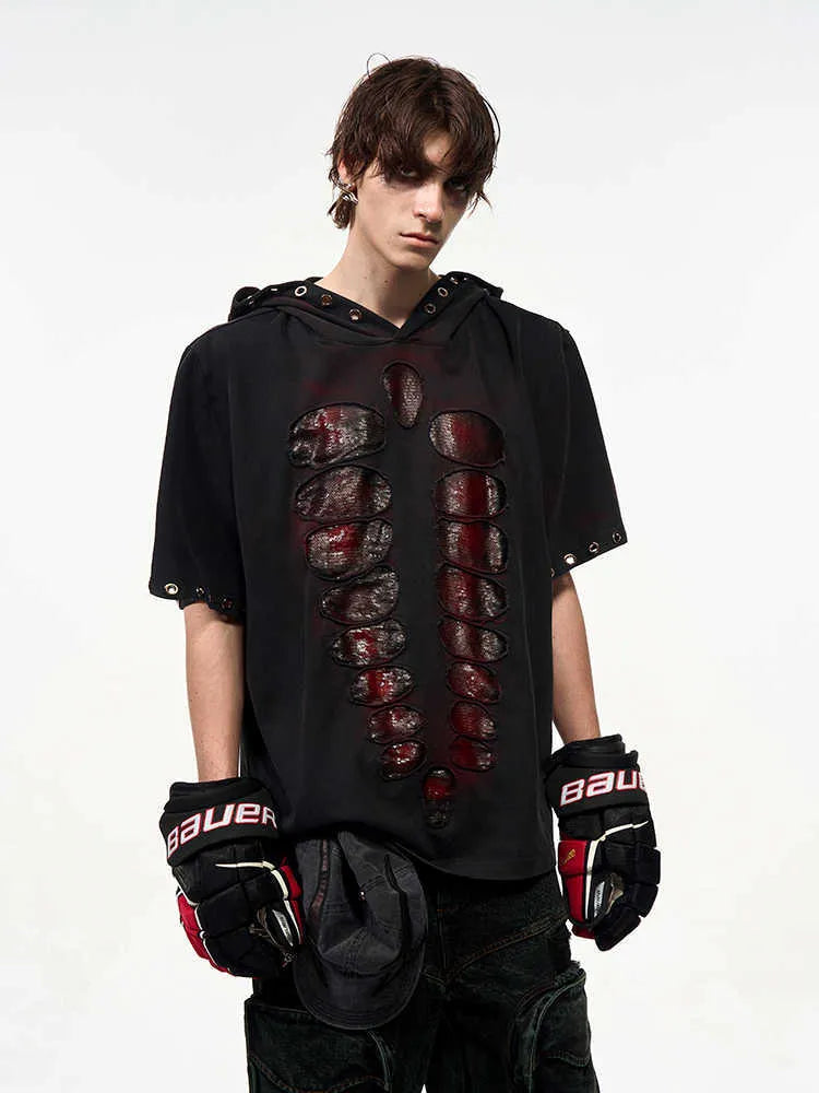 Man wearing a black hooded T-shirt covered in sequins, showing loose fit and short sleeves.