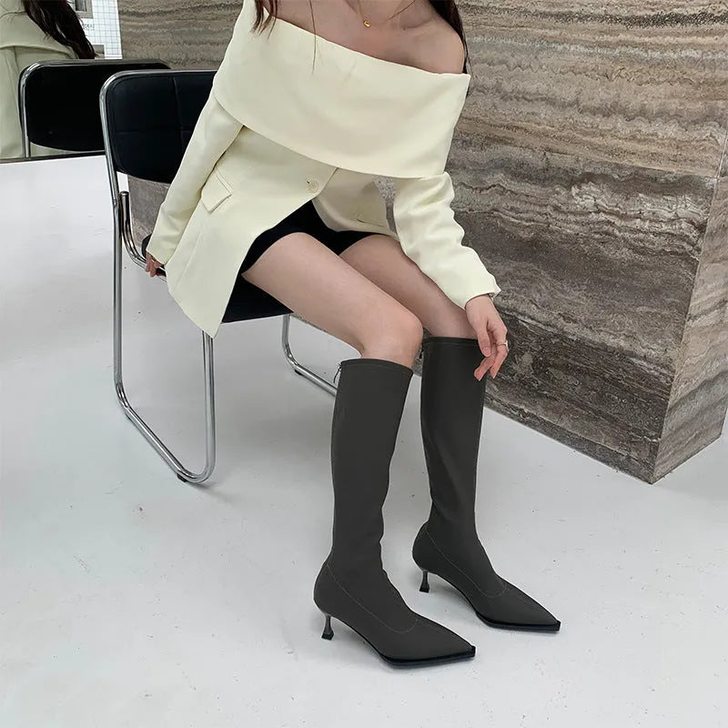 Black pointed toe stiletto heel boots with a back zipper, showing the below-the-knee shaft height.
