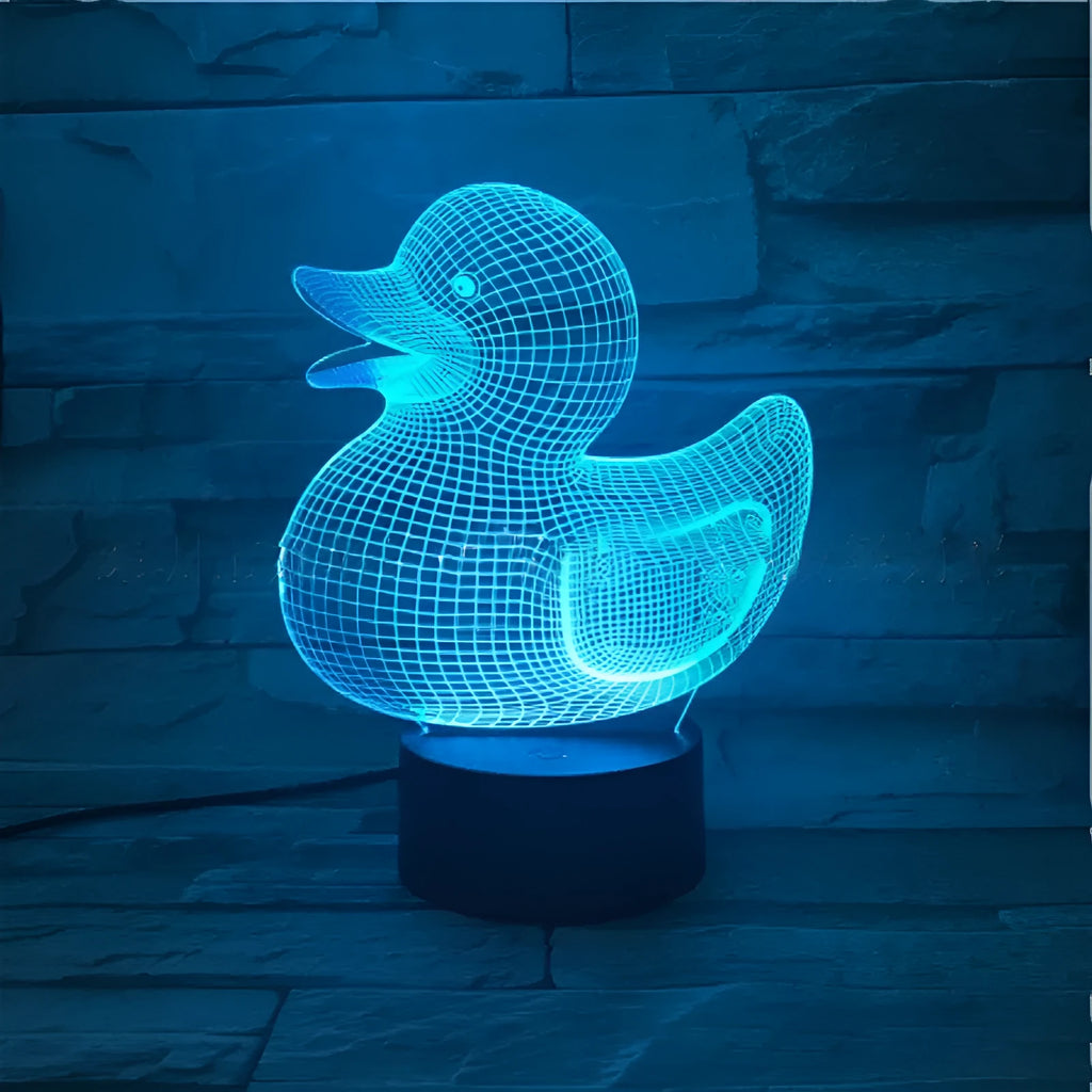 3D Little Yellow Duck night light glowing in multiple colours on a desk with remote control.