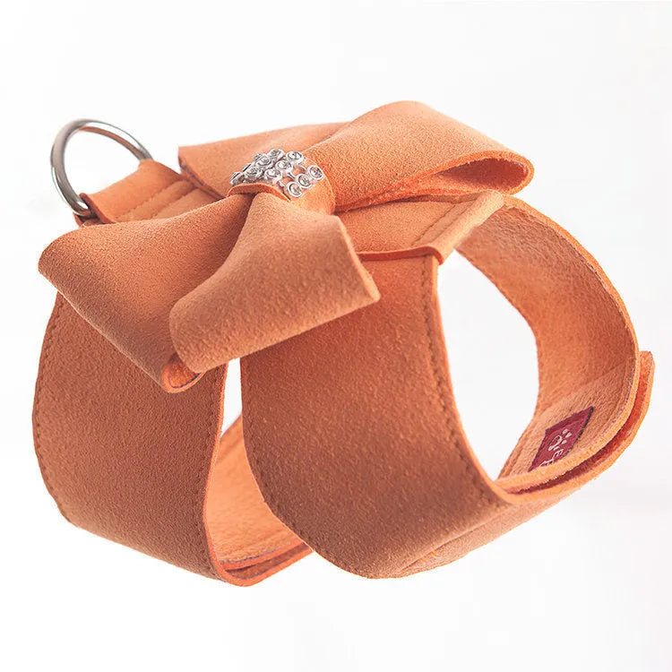 Pink microfiber dog chest strap with a large white bowknot, showing adjustment buckle and D-ring.