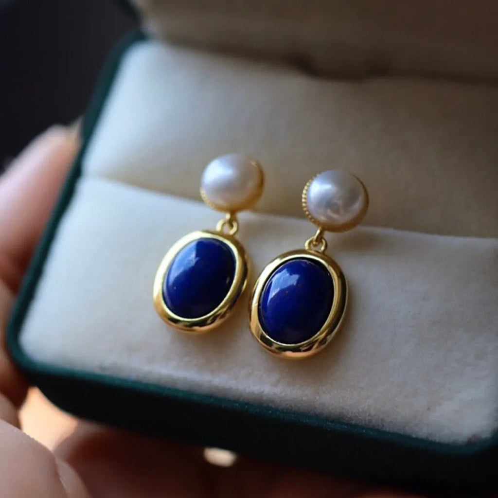 A pair of simple 925 silver earrings with a blue lapis lazuli pearl and auspicious pattern details.