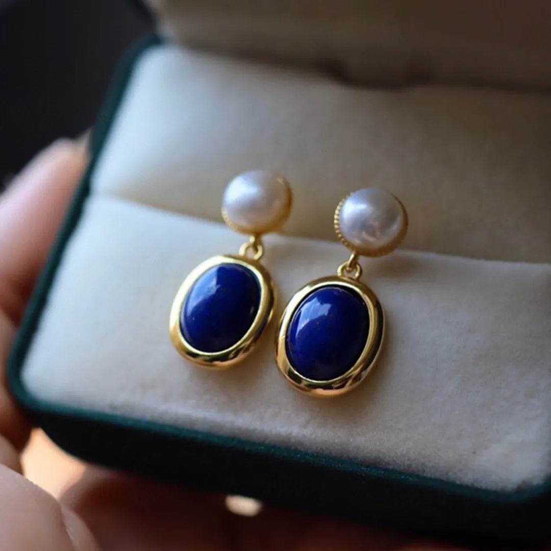 A pair of simple 925 silver earrings with a blue lapis lazuli pearl and auspicious pattern details.