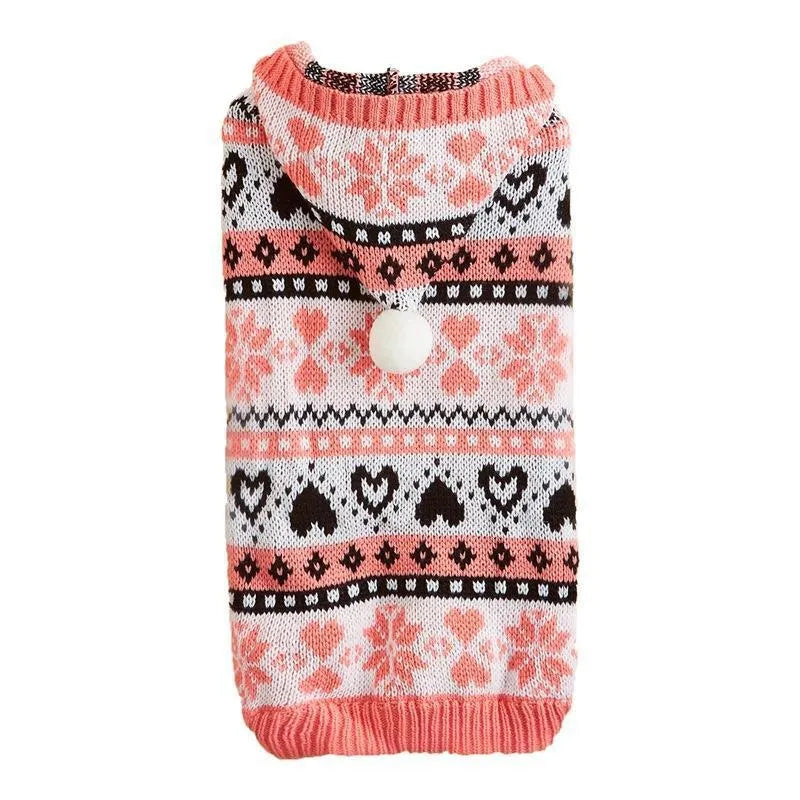 Pink knitted dog sweater with snowflake and striped camouflage patterns on a small Bichon dog