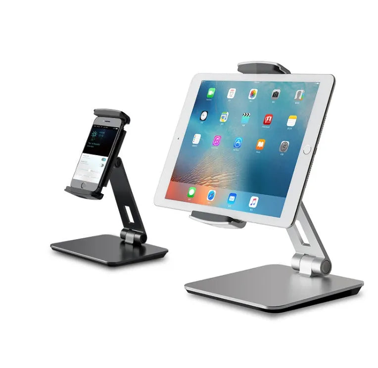 Folding aluminium and black plastic phone tablet stand on a desk, showing 360 degree rotation base.