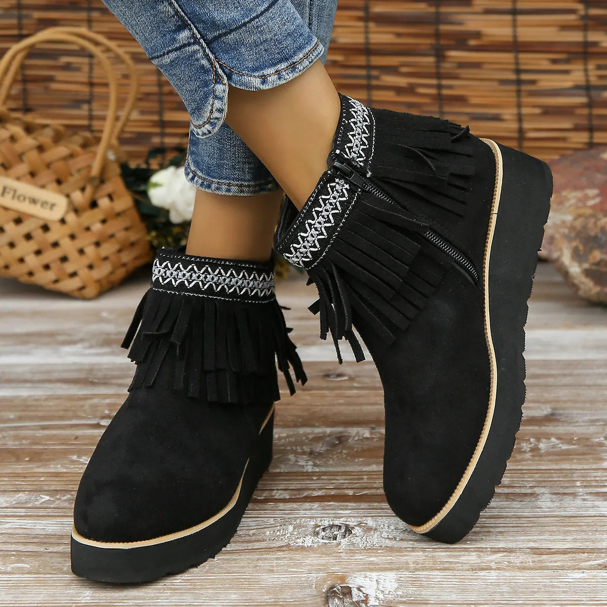 Women's dark brown suede ankle booties with a wedge heel, side zipper, and tassel detail