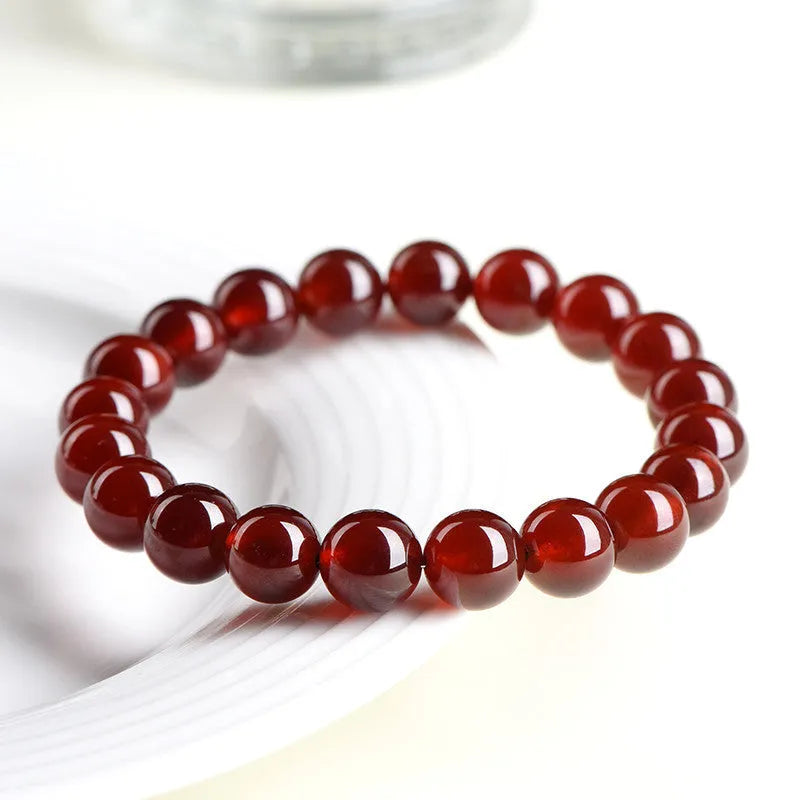 Natural orange red garnet ball bracelet with ruyi element in retro unisex design on wrist