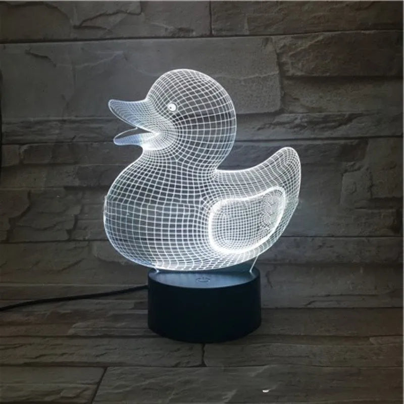 3D Little Yellow Duck night light glowing in multiple colours on a desk with remote control.