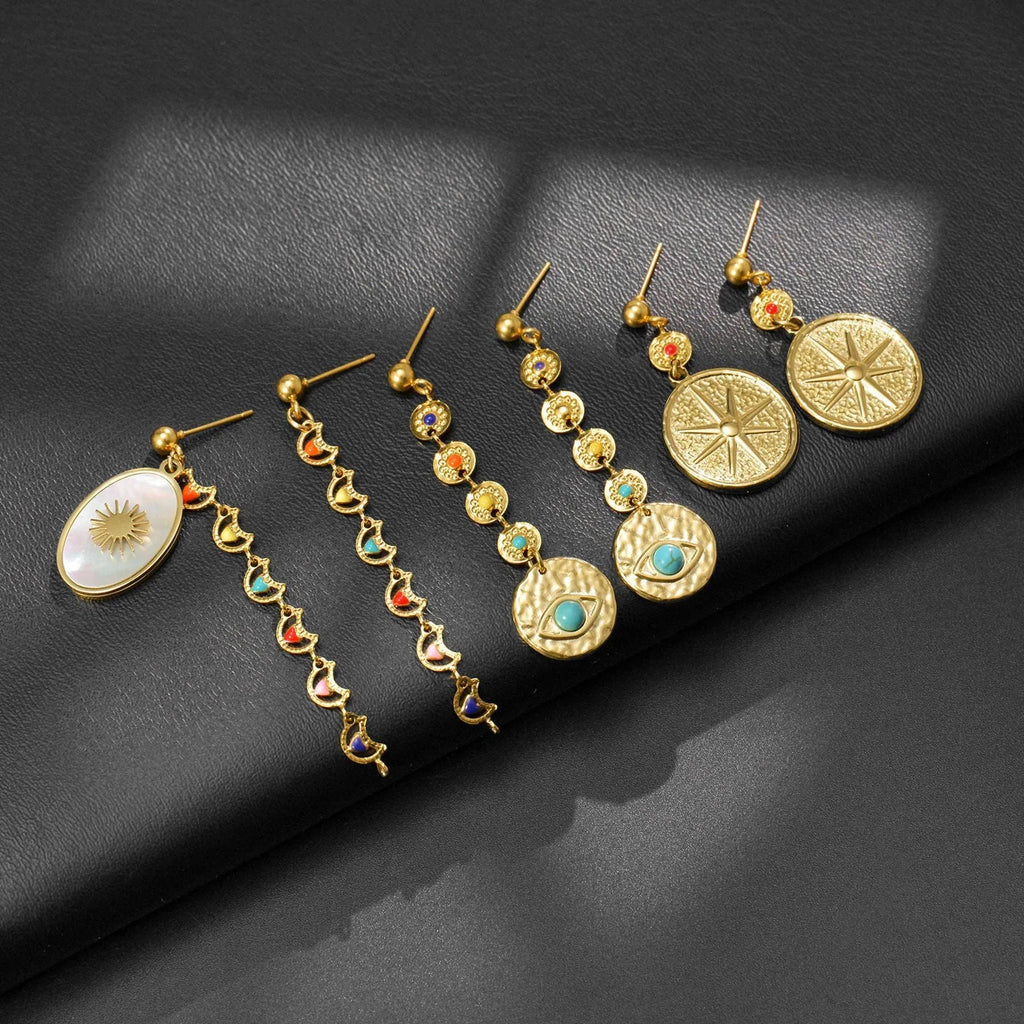 Three pairs of geometric stainless steel earrings: eight-point star, eye motif and shell sun designs
