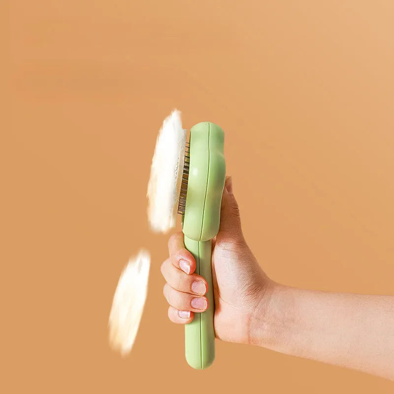Green cat comb with stainless steel needles and self-cleaning magic wand function on white background
