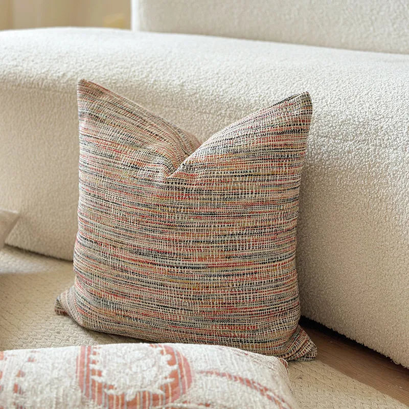 American-style amber jacquard pillow cover with paisley plant pattern, shown on a sofa.