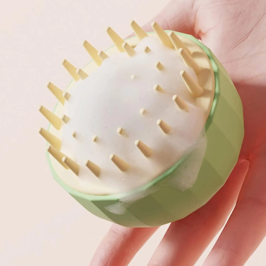 Green pet bath massage brush with silicone bristles and drain holes on a white background.