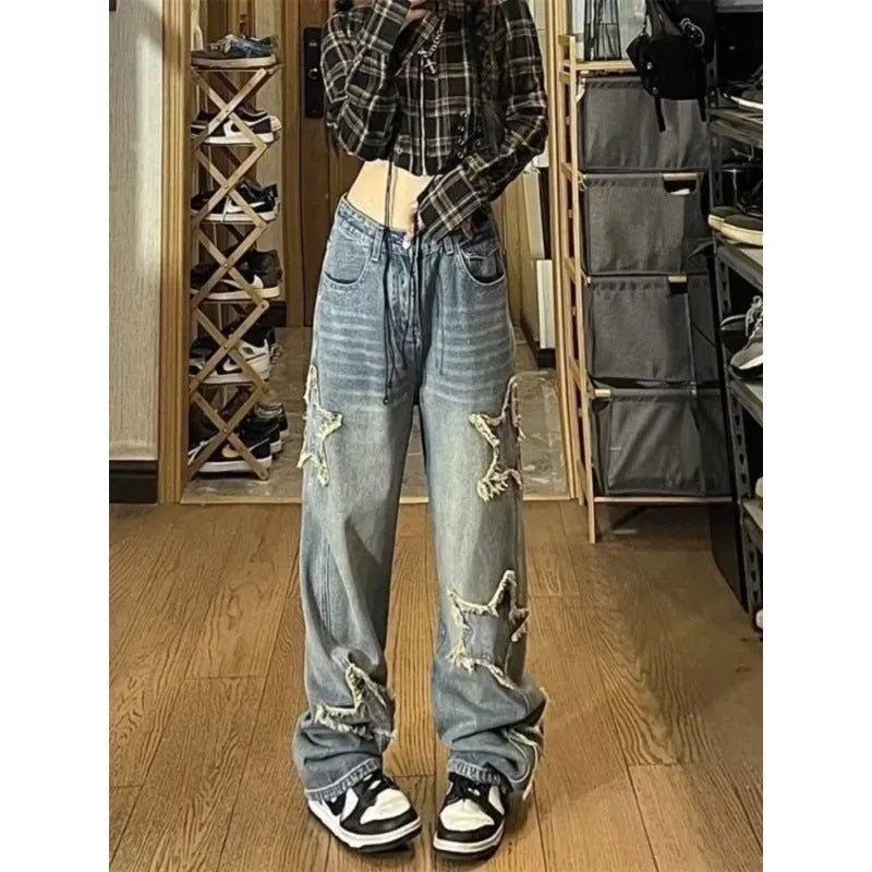 Blue high-waisted wide-leg denim trousers on a hanger, showing the straight-leg silhouette.