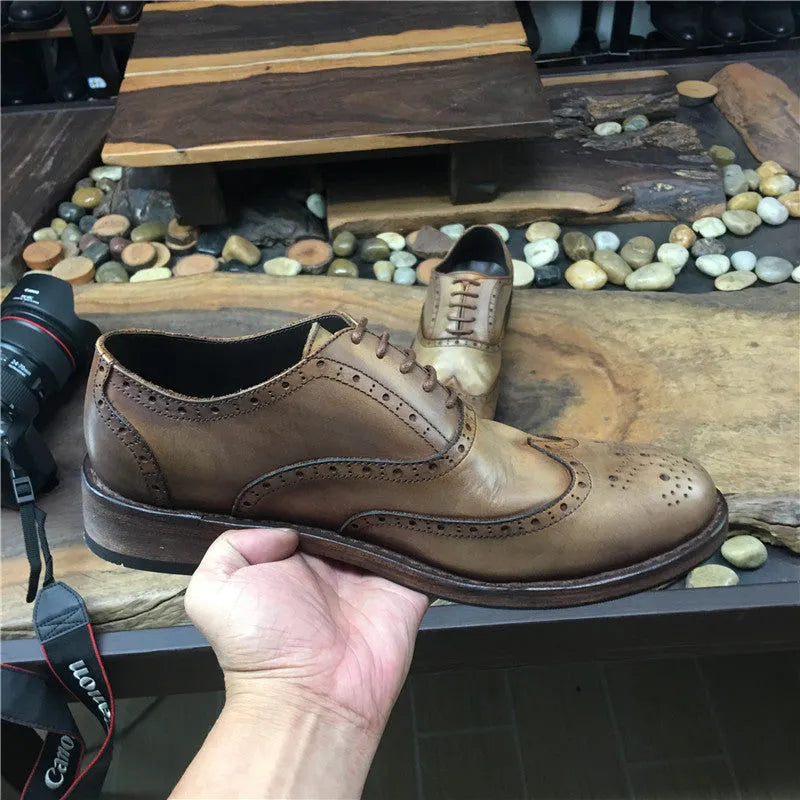 Men's light brown vintage leather lace-up shoes with carved detailing and a round toe.