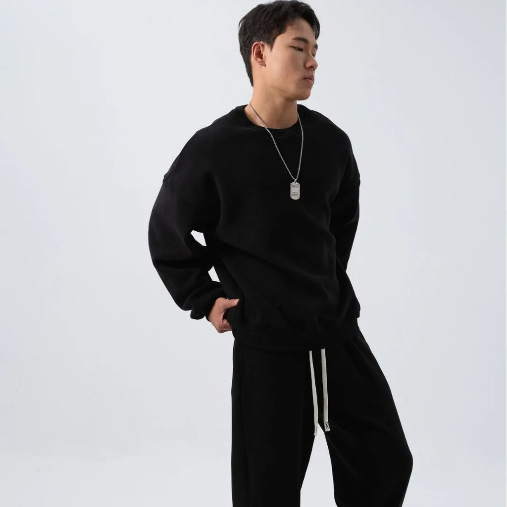 Man wearing a black loose-fit polar fleece sports suit with crew neck top and padded trousers for winter.
